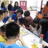 Volunteer teach the visually impaired how to play the board game