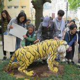 Participants of the pilot visit are touching the tiger figure in the Haw Par Music Farm