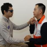 導譯員運用觸感手語與視聽障人士溝通