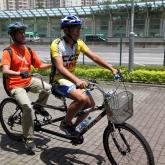 one visually impaired and sighted person riding tandem
