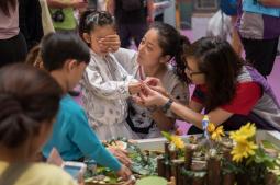 小朋友閉上眼睛觸摸由視障人士製作的陶泥手工藝