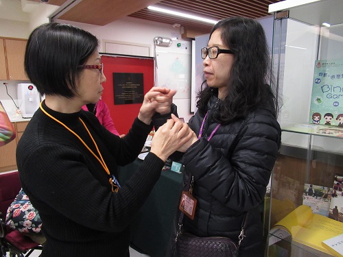 During the exchange tour, communicator (right) interpreted the content for the deafblind (left) by Tactile Sign Language