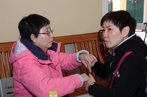 During the exchange tour, communicator (right) interpreted the content for the deafblind (left) by Tactile Sign Language