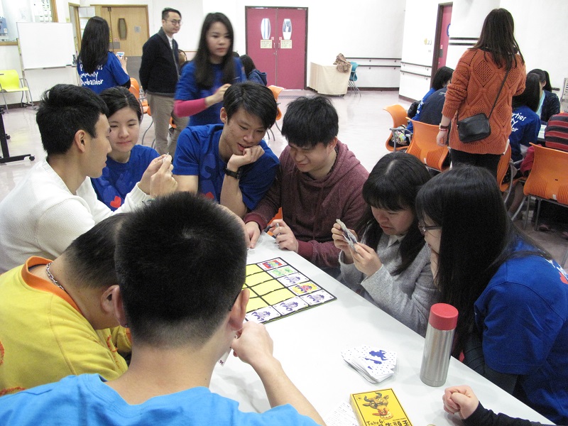 Volunteer teach the visually impaired how to play the board game
