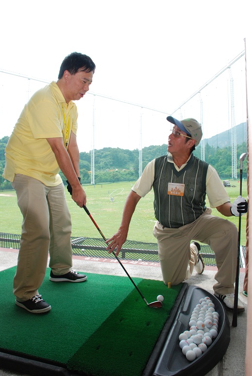 關愛大使譚詠麟親自教授本會會員譚世鴻如何打高球。