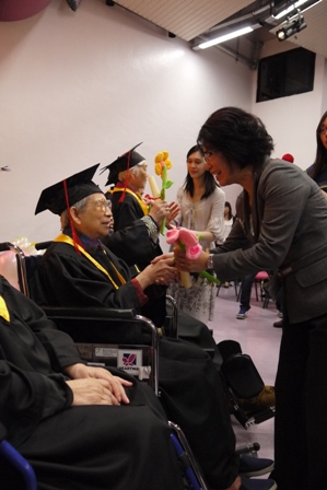 行政總裁譚姑娘頒發畢業證書予長者