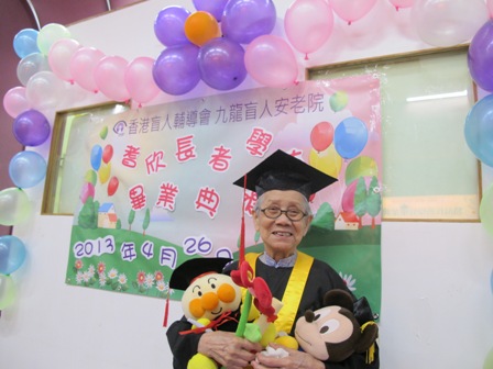 長者在美麗的佈置下拿著證書、花和公仔影畢業相
