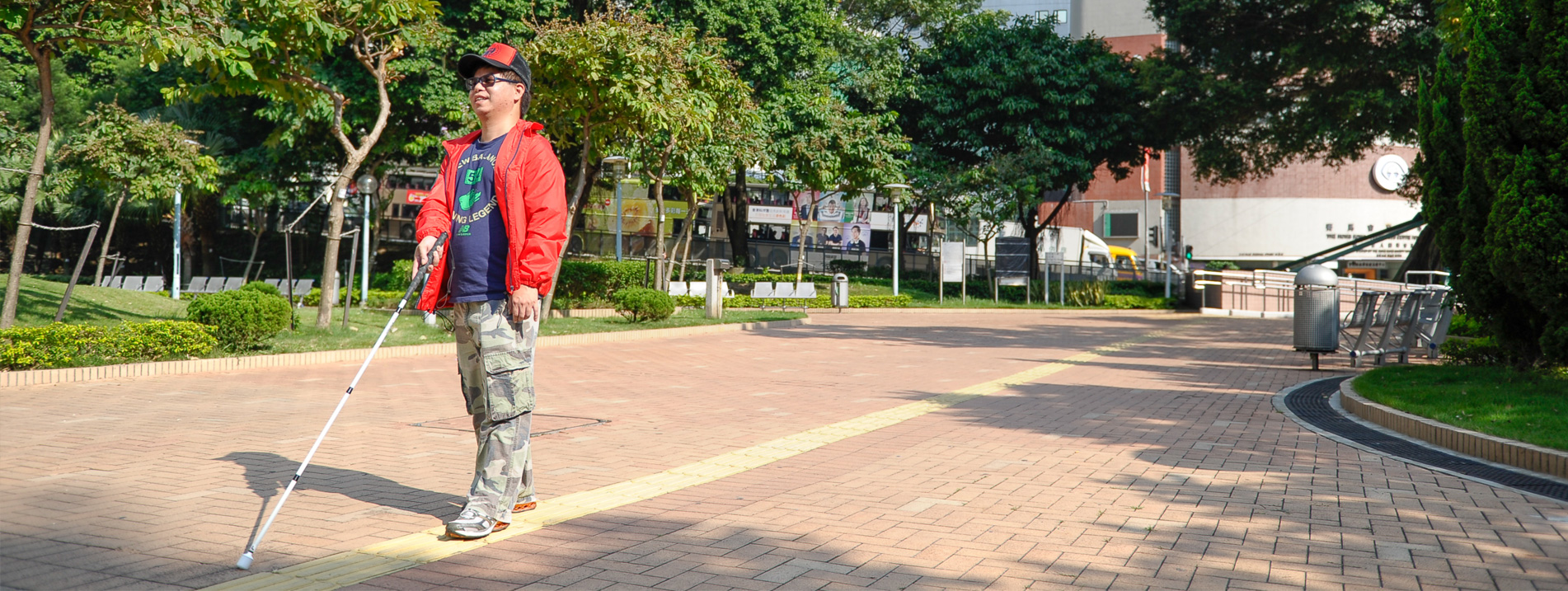 A visually impaired person walking with a cane 