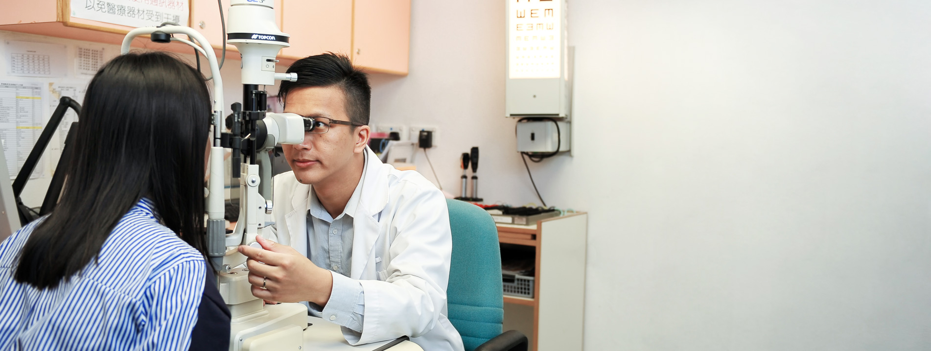 An optometrist conduct vision screening for a patient 